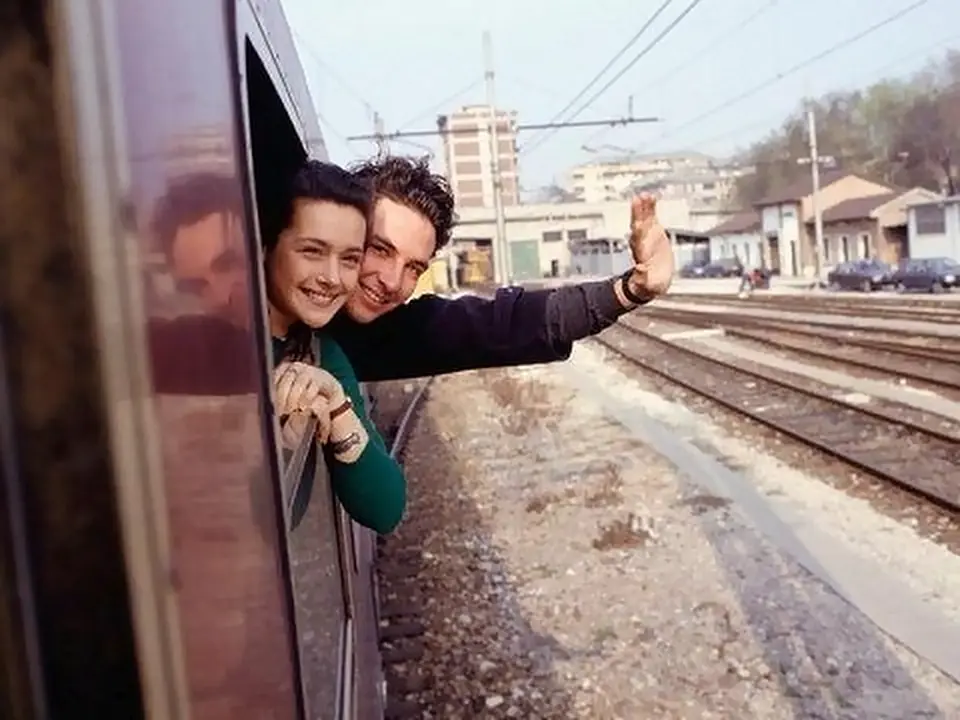 Due sposi salutano dal finestrino di un treno